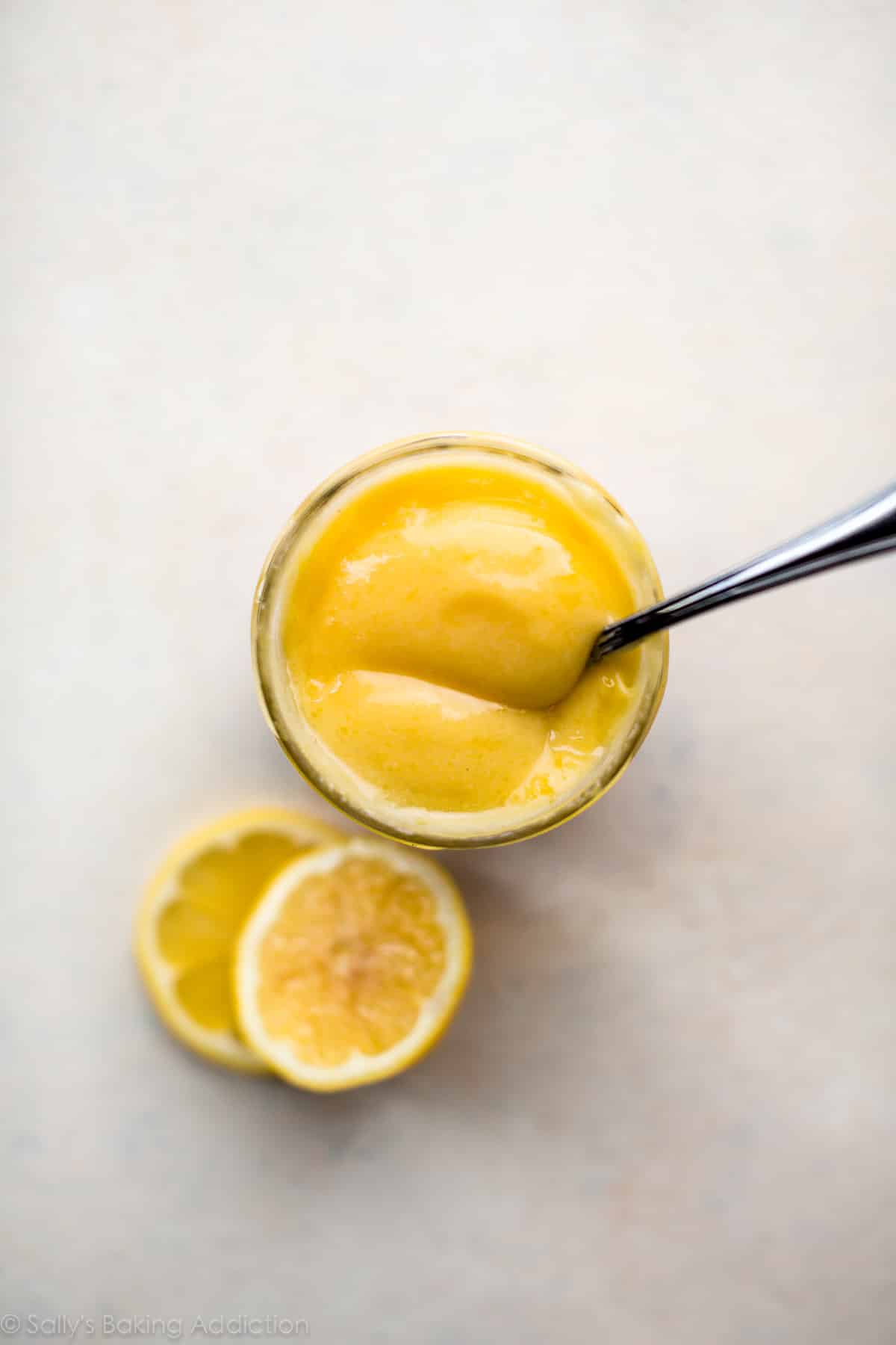 Lemon curd in a jar with a spoon