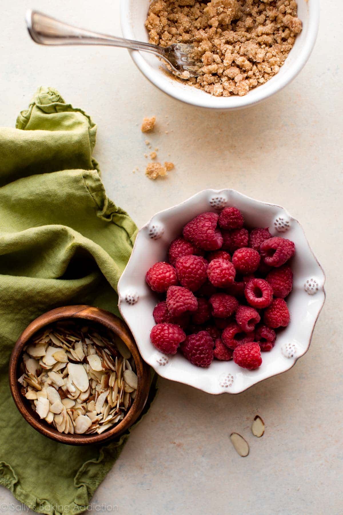raspberries, sliced almonds, and crumb topping in bowls