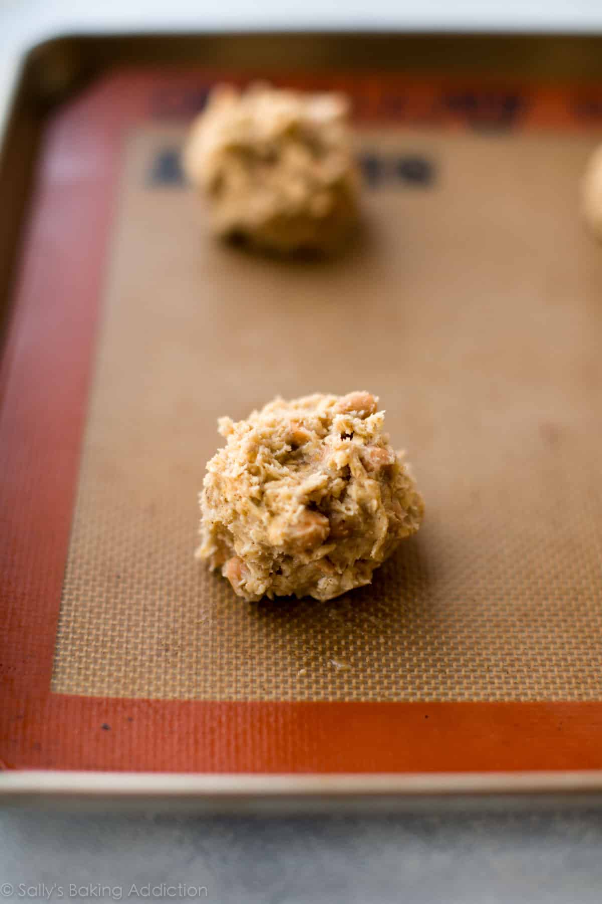 oatmeal scotchies cookie dough on a baking sheet before baking