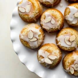 overhead image of almond poppy seed tea cakes on a cake stand