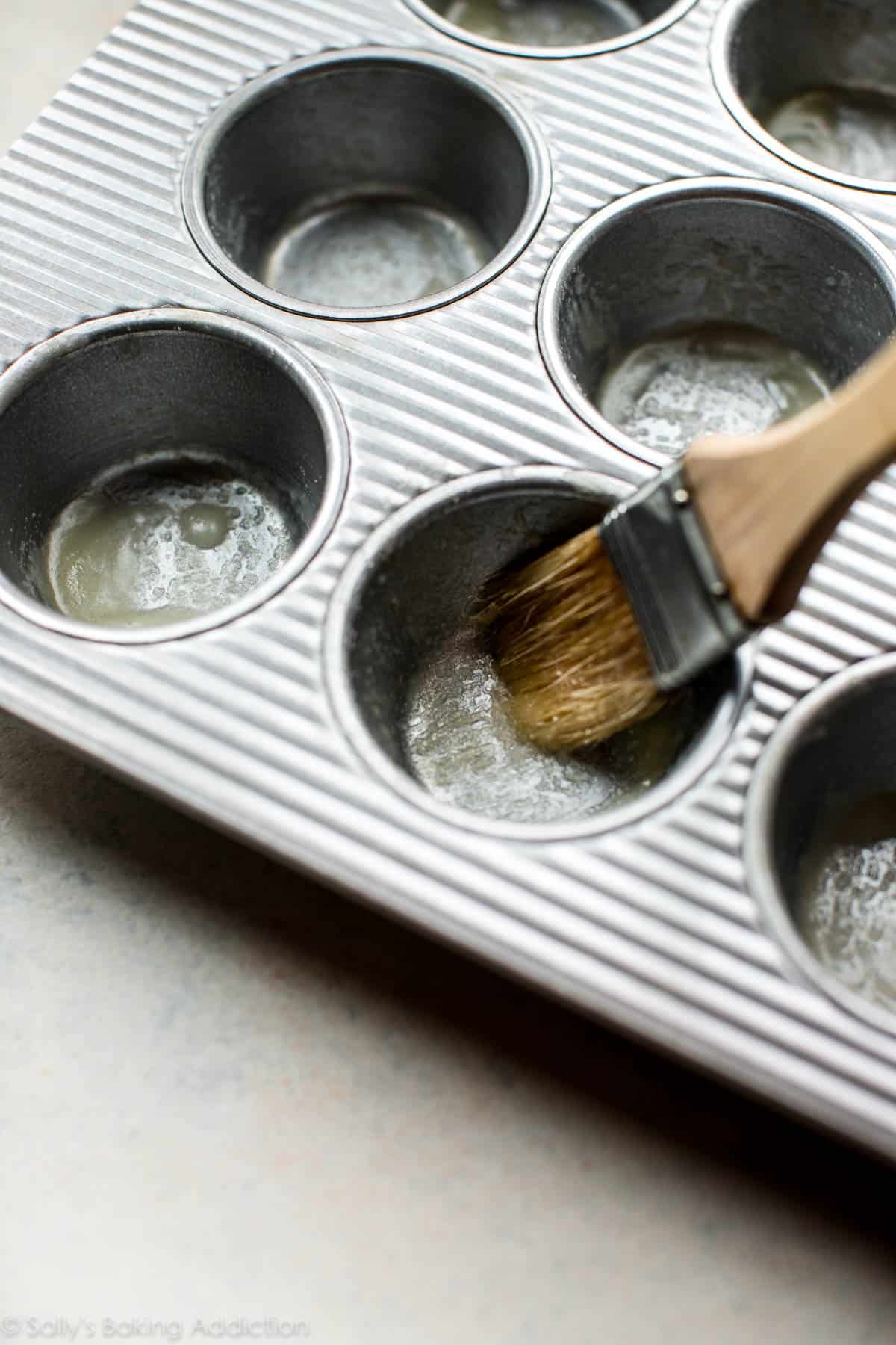 Brushing the muffin pan with melted butter and sugar