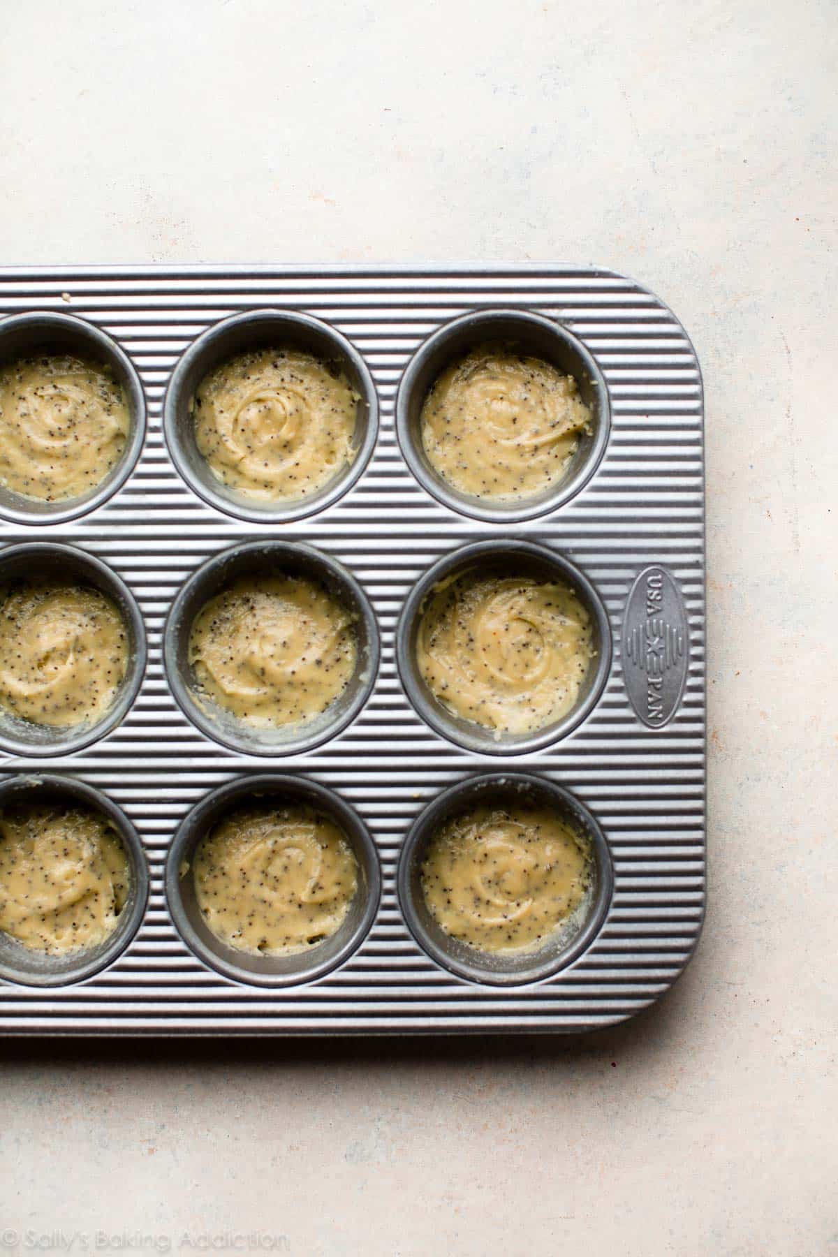 almond poppy seed tea cake batter in a muffin pan