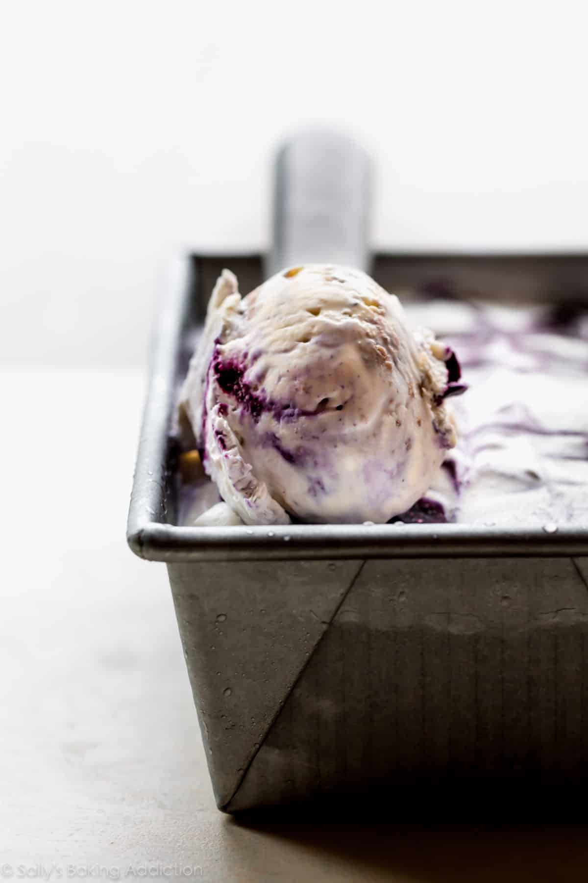 scoop of no churn blueberry crumble ice cream in a loaf pan