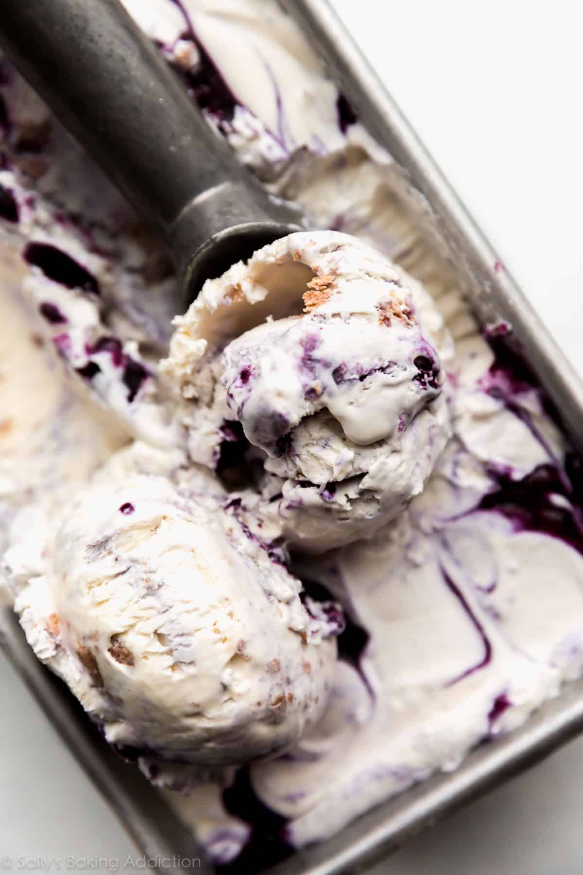 no churn blueberry crumble ice cream in loaf pan with an ice cream scoop