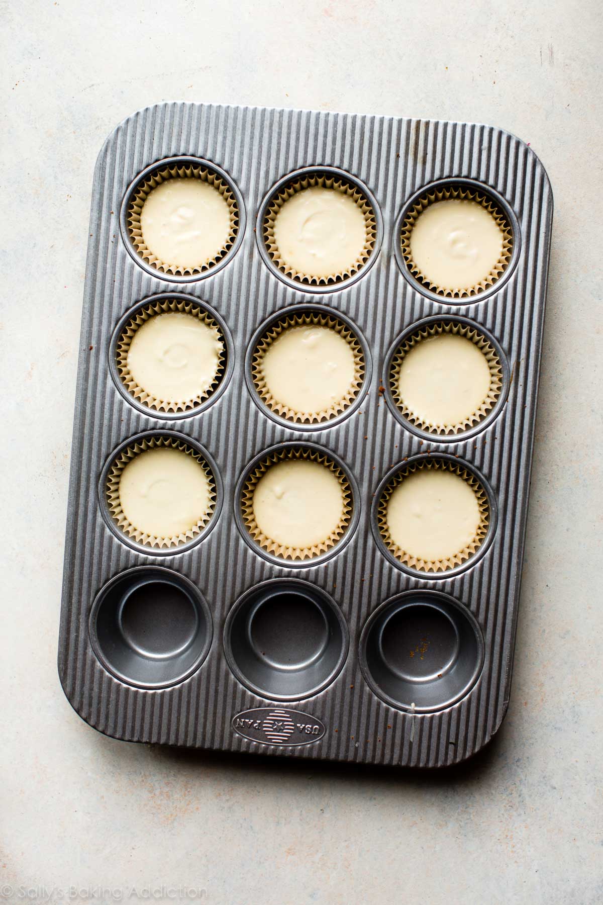 cheesecake batter in a muffin pan before baking