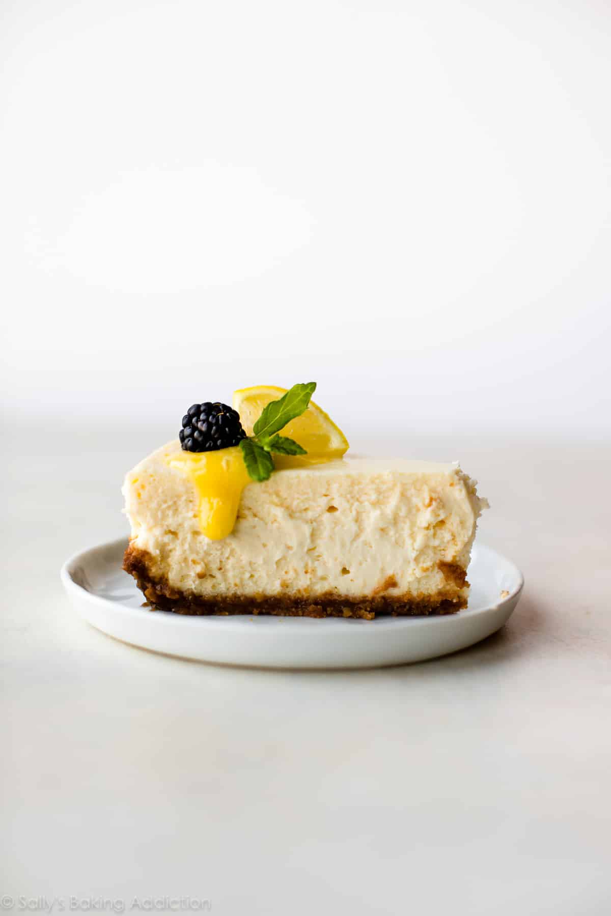 slice of cheesecake on a white plate with lemon curd topping