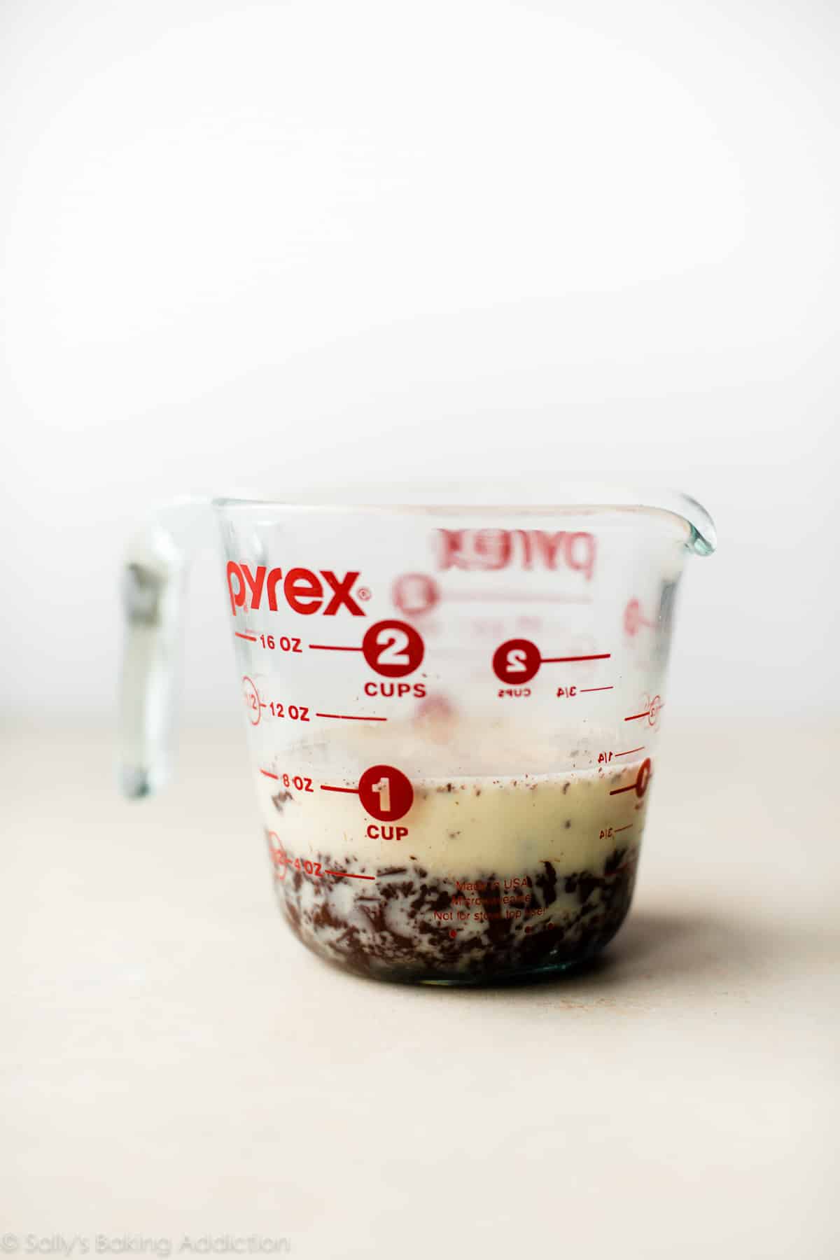 heavy cream, corn syrup, and chocolate in a glass measuring cup