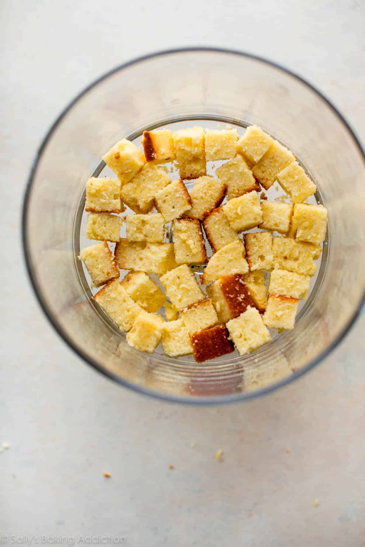 overhead image of cubes of lemon pound cake in the bottom of a glass trifle dish