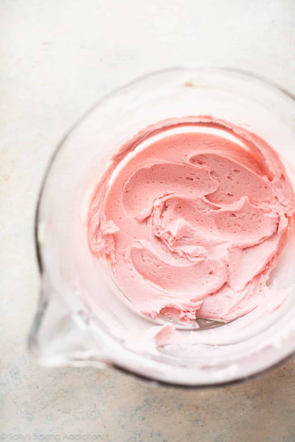pink buttercream frosting in a glass bowl