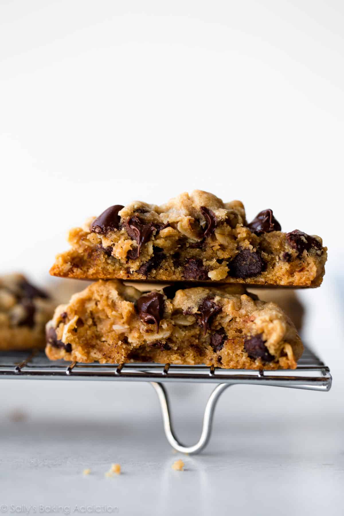 peanut butter oatmeal chocolate chip cookie broken in half and stacked on a cooling rack