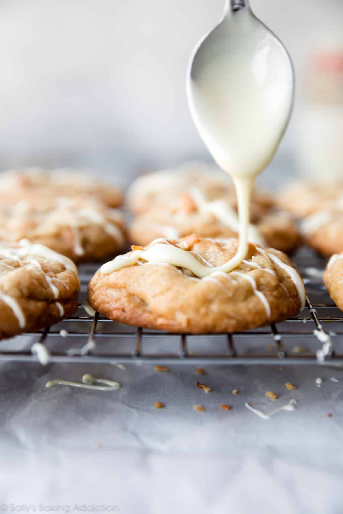 drizzling melted white chocolate onto coconut macadamia nut cookies
