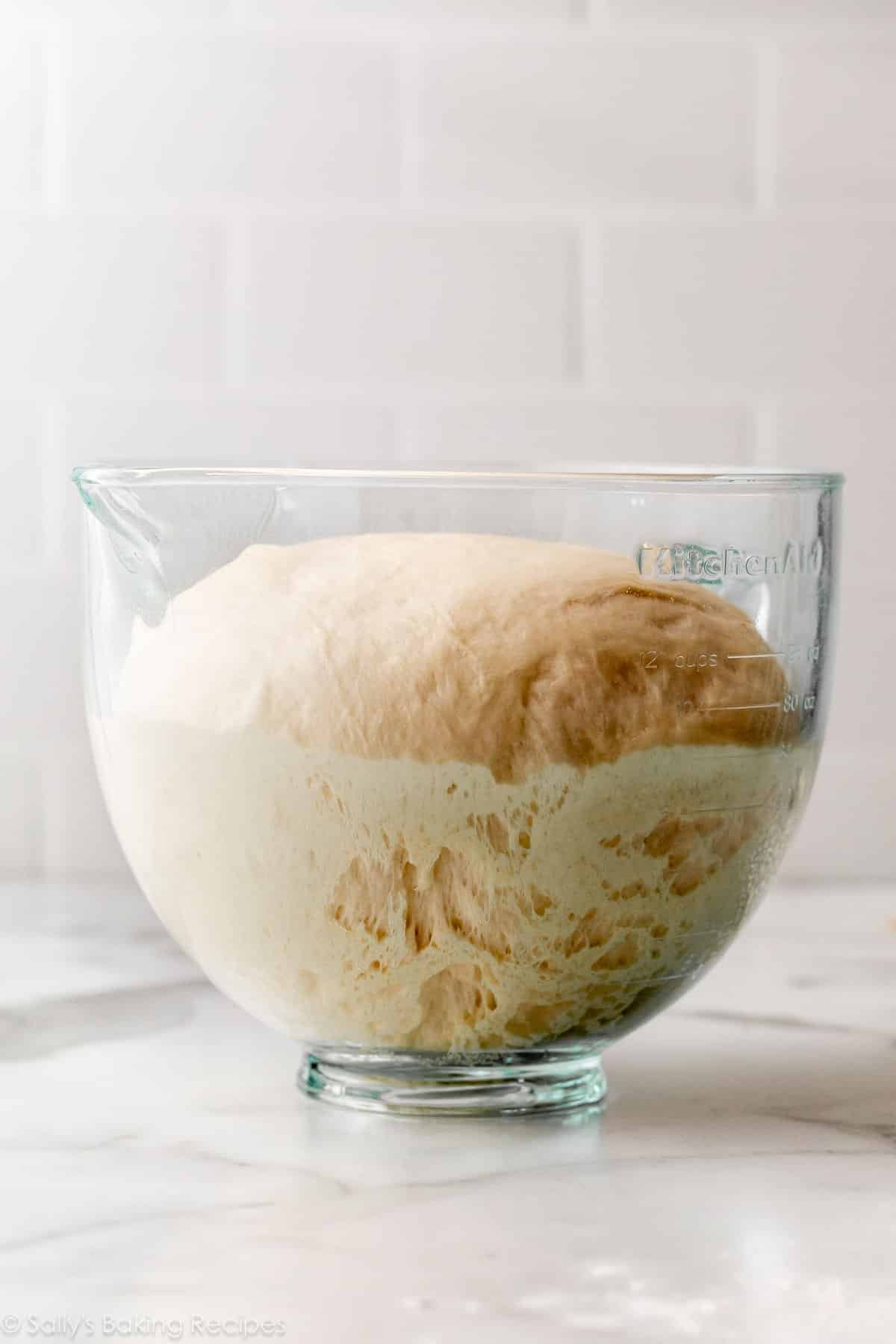 glass bowl with risen dough inside.
