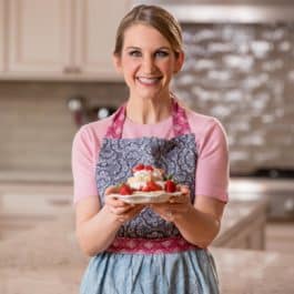 sally in the kitchen holding a plate of strawberry shortcake