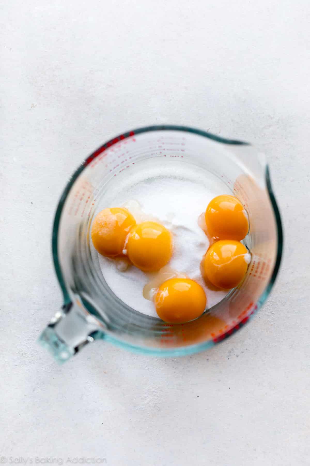 Egg yolks and sugar in a large glass measuring cup