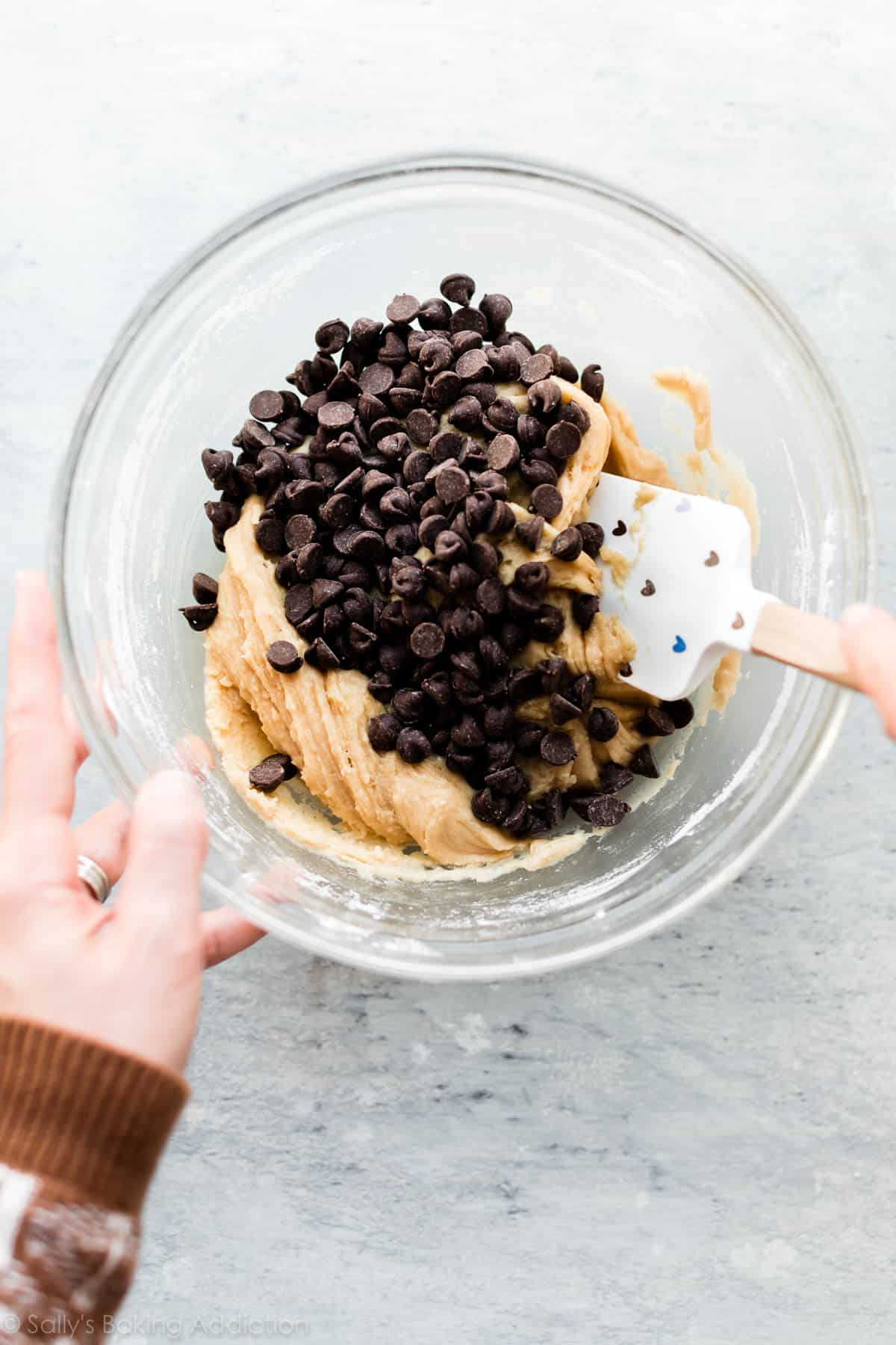 Chocolate chip cookie dough in a glass bowl with a spatula