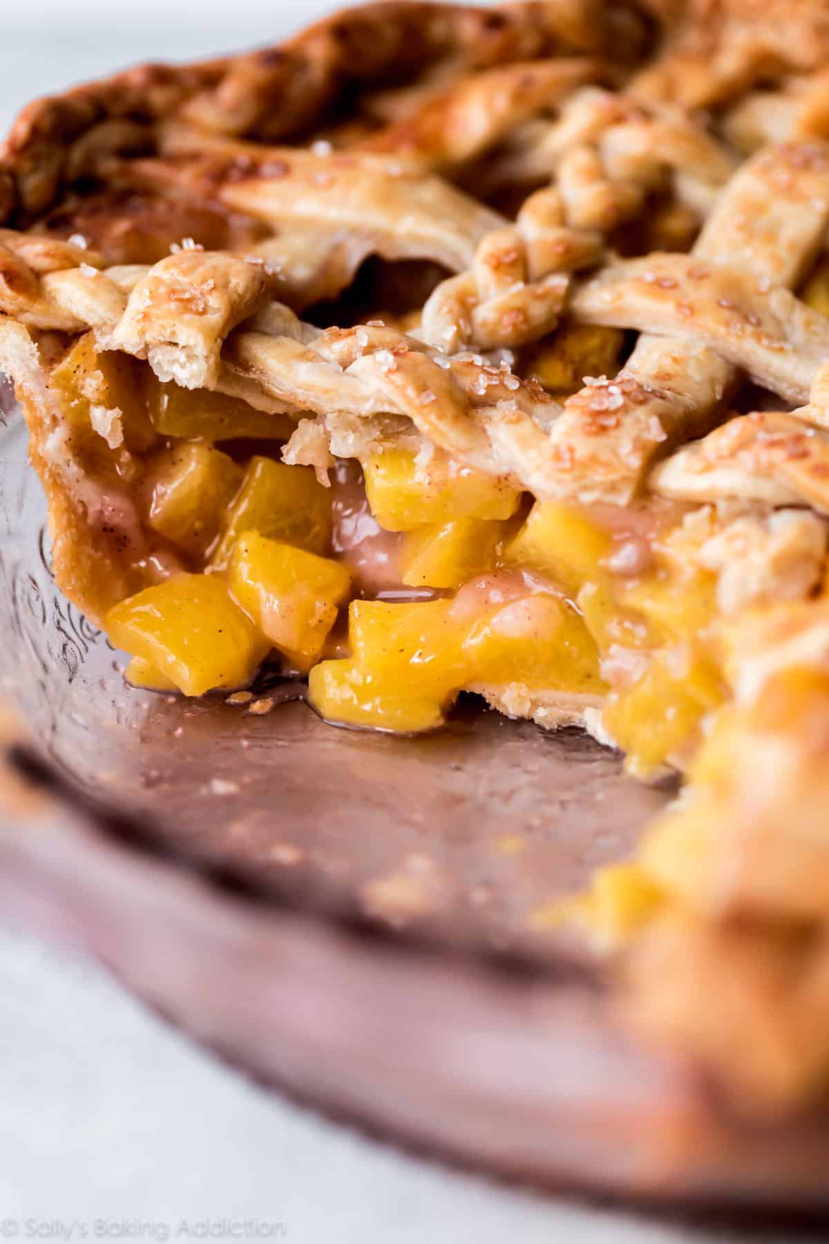 side view of peach pie in a pie dish