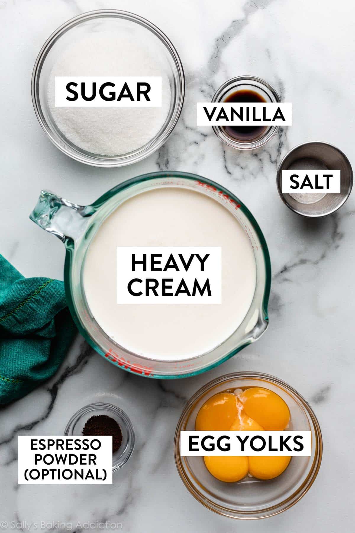 ingredients on counter including bowl of egg yolks, espresso powder, heavy cream, sugar, vanilla, and salt.