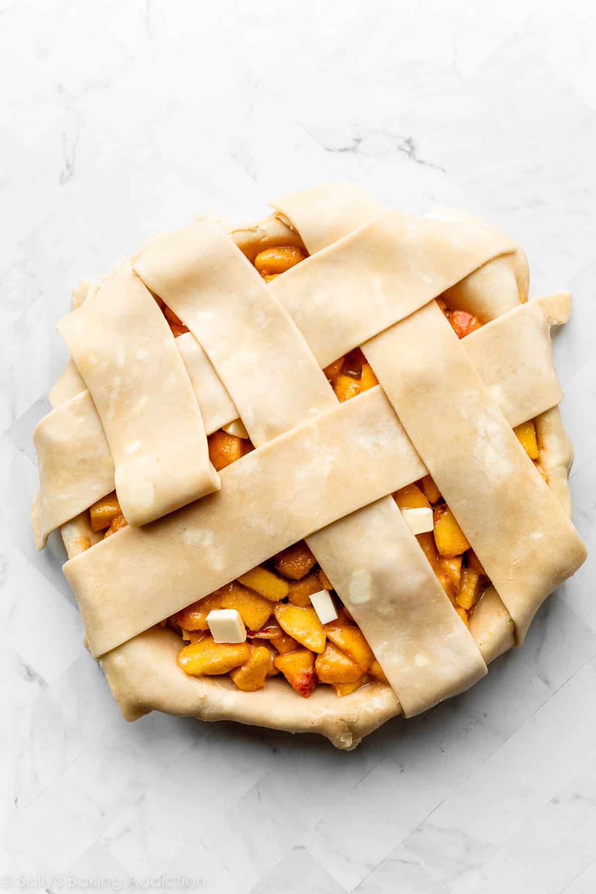 assembling lattice topping with thick pie dough strips.