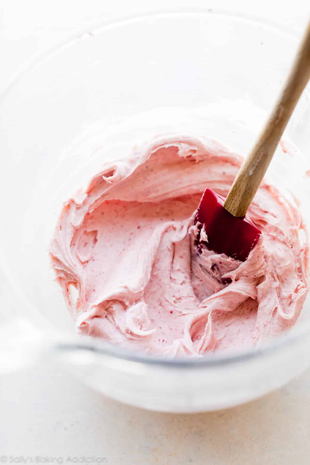 Creamy strawberry white chocolate frosting in a glass bowl