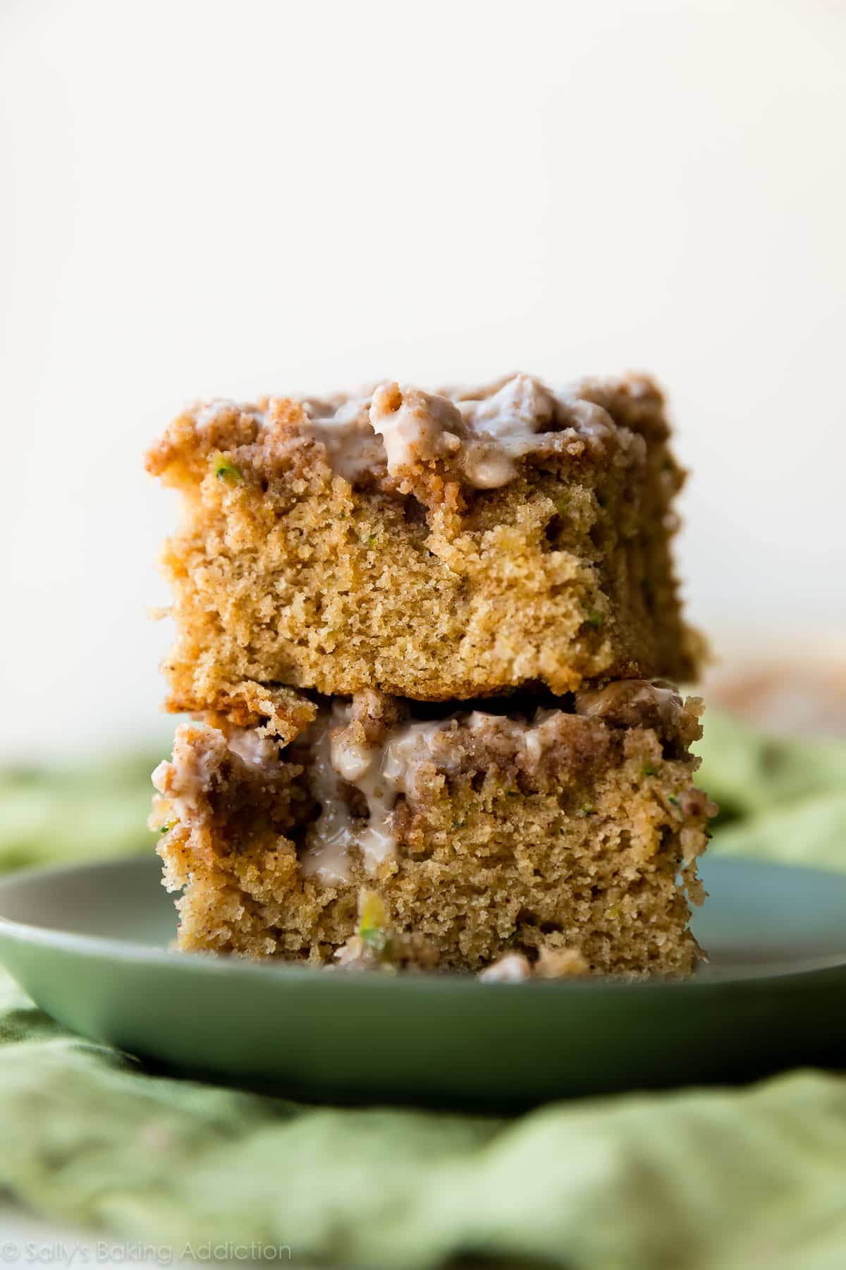 stack of 2 zucchini crumb cake pieces on a green plate