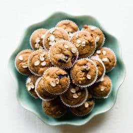 overhead image of baby muffins stacked on a teal plate