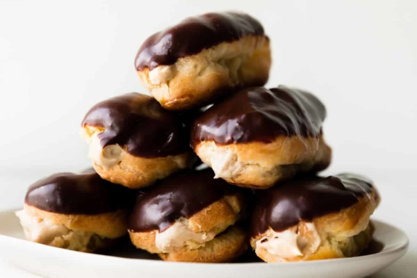 eclairs stacked on a white plate