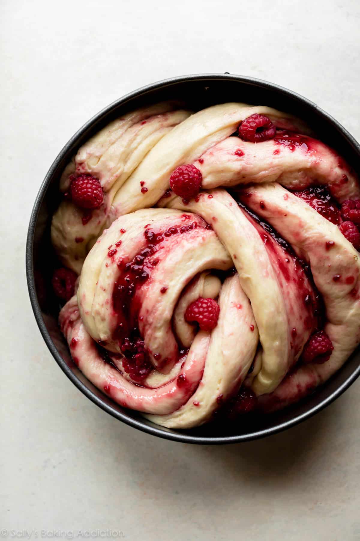 shaped raspberry danish twist dough in round pan before baking