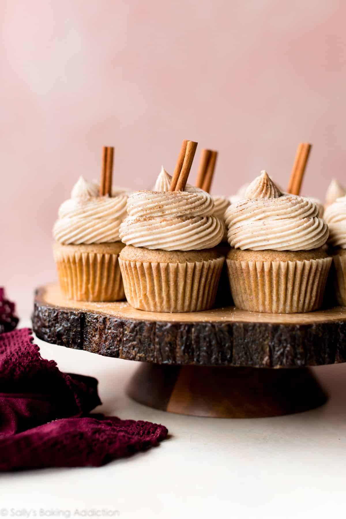 chai latte cupcakes on a wood slice cake stand