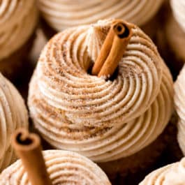 chai buttercream swirled on cupcakes with cinnamon stick garnish