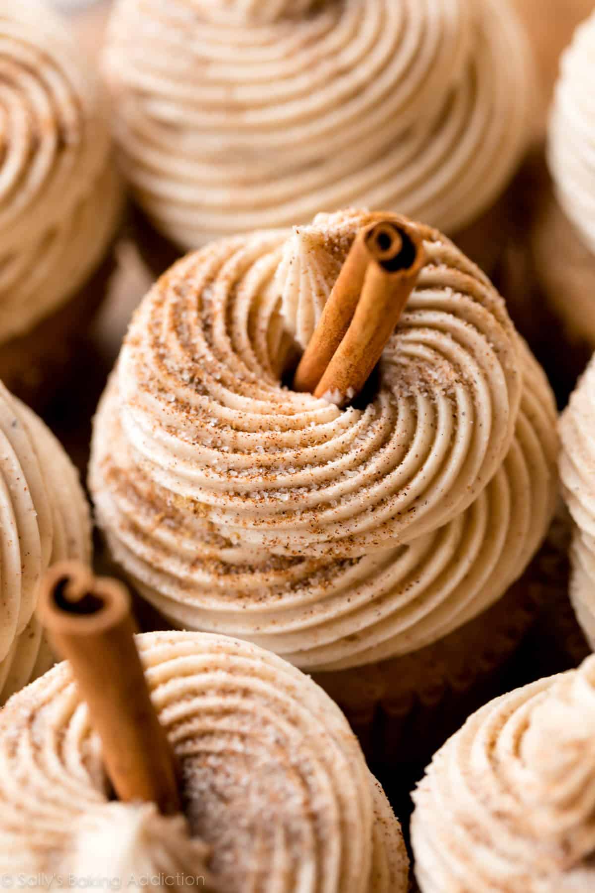 chai buttercream swirled on cupcakes with cinnamon stick garnish