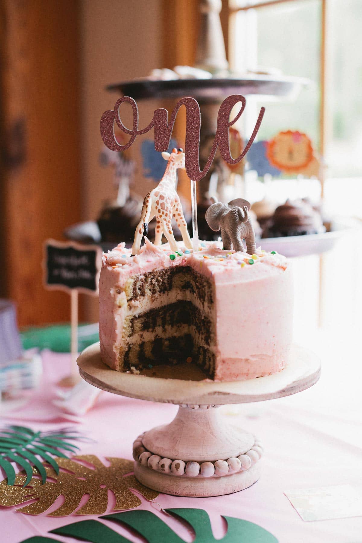 image of the inside of a 3 layer marble cake with strawberry frosting on a cake stand