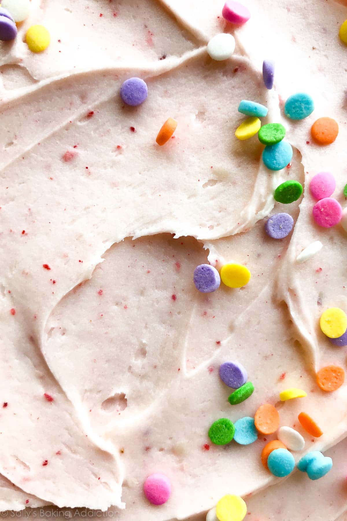 zoomed in image of strawberry frosting with sprinkles