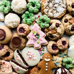 assortment of Christmas cookies including sugar cookies, gingerbread cookies, thumbprints, oatmeal cookies, coconut macaroons, and spritz cookies