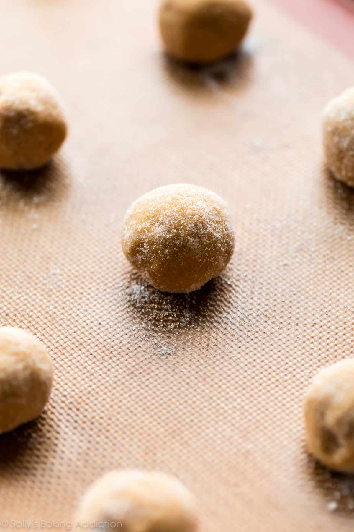 Peanut butter cookie dough rolled into balls on a silpat