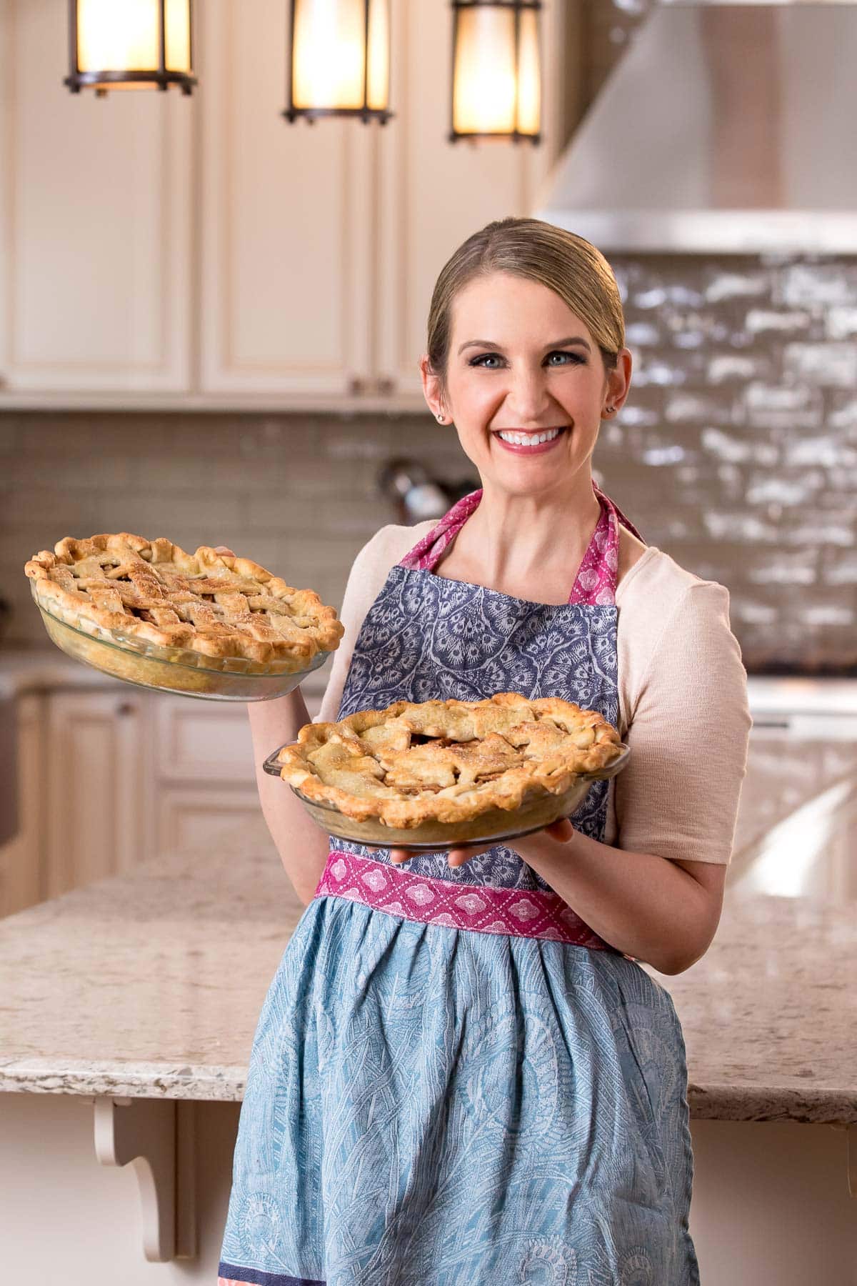 sally in the kitchen holding 2 pies