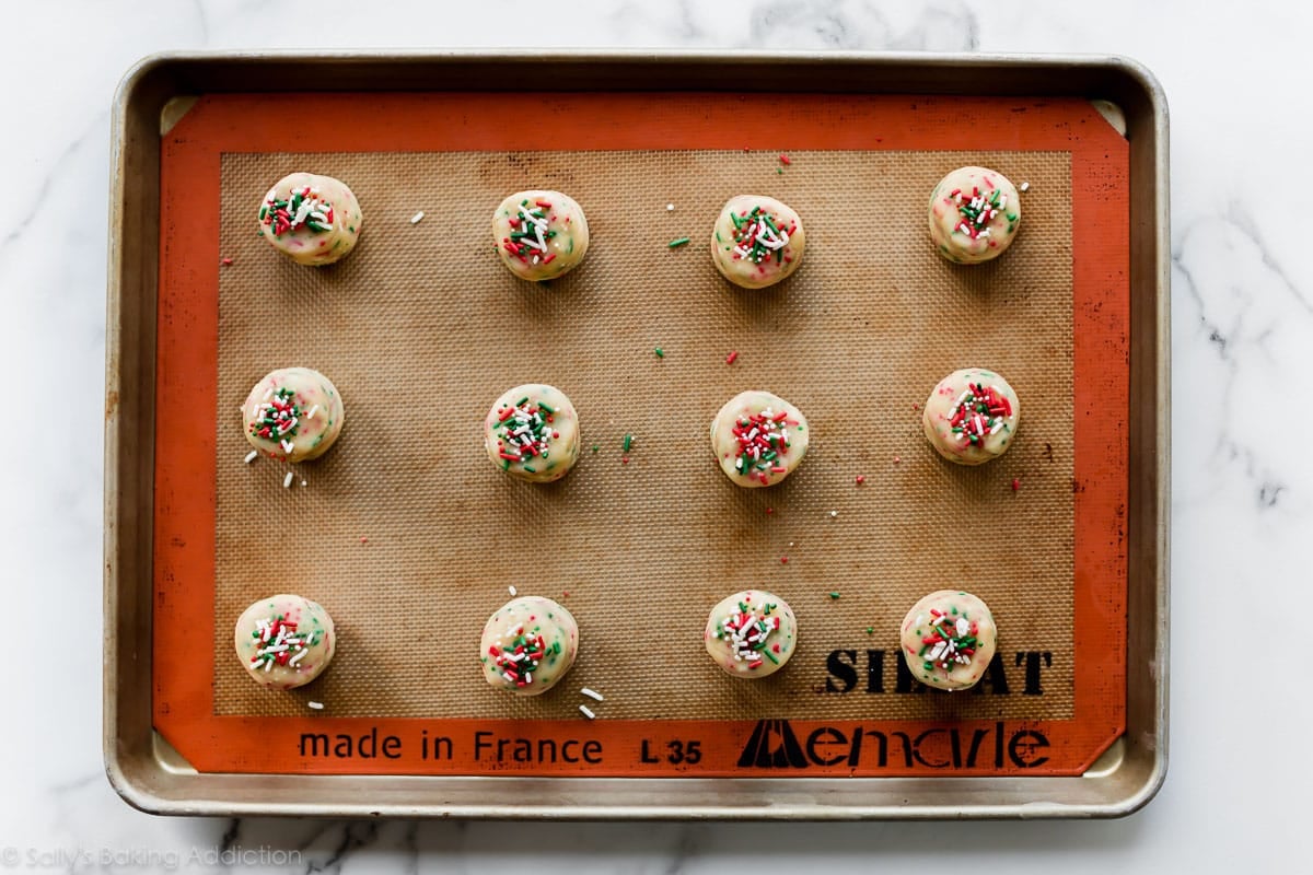 Sugar cookie dough balls on Silpat baking mat before baking