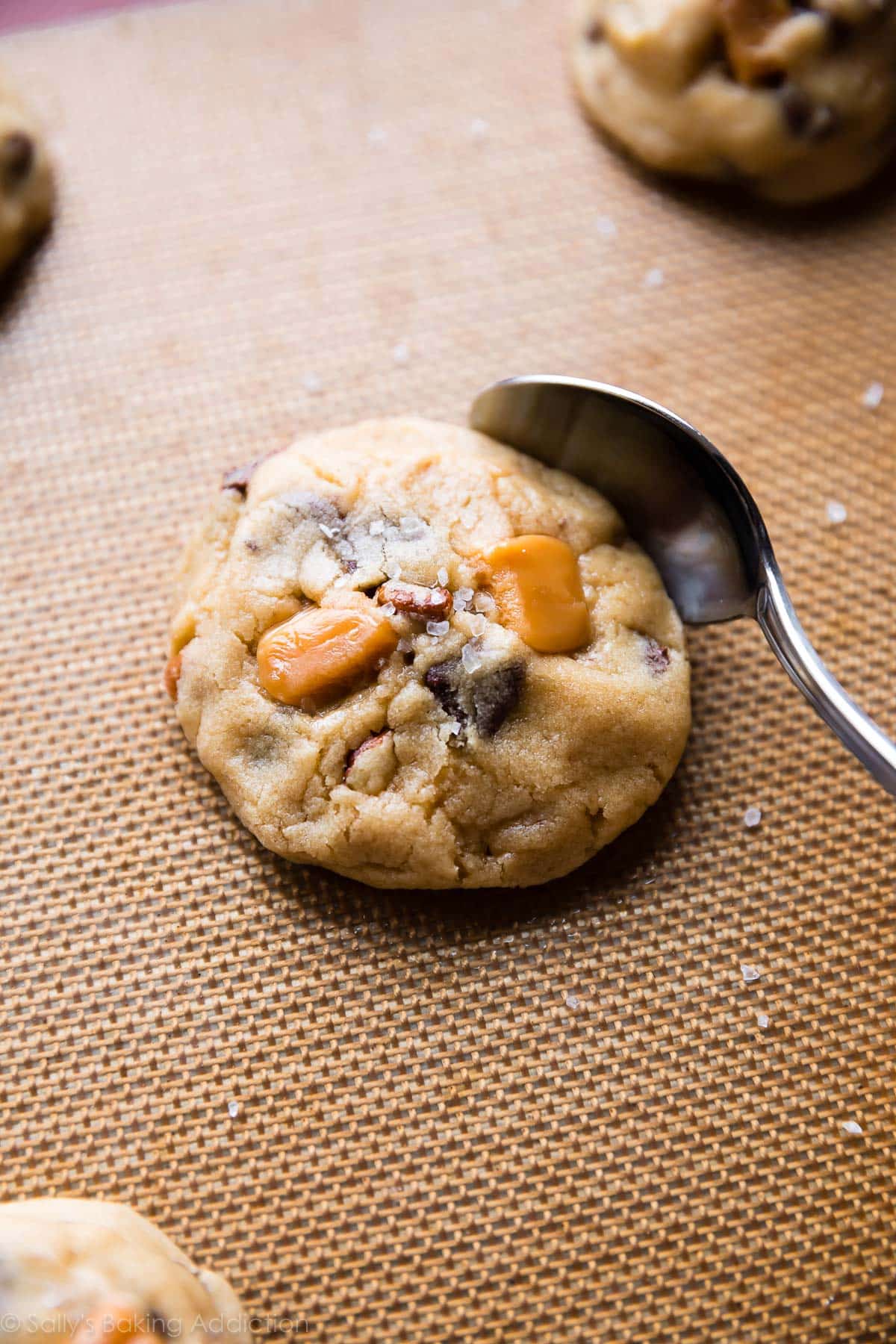 Caramel cookie after baking with a spoon shaping the edges