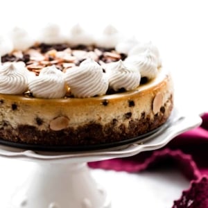 Amaretto chocolate chip cheesecake on a white cake stand