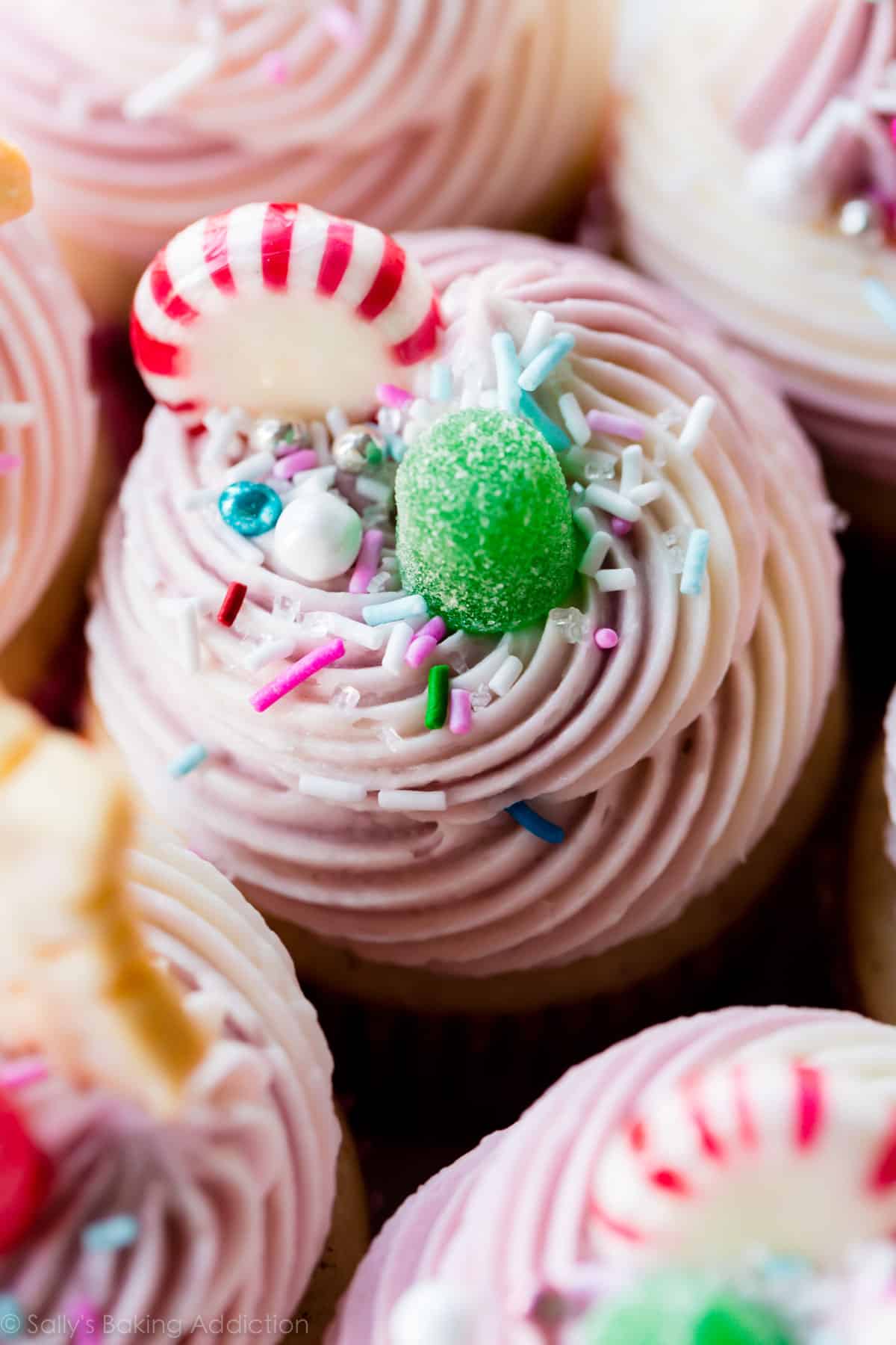 cupcakes with swirls of purple vanilla almond buttercream and candies and sprinkles