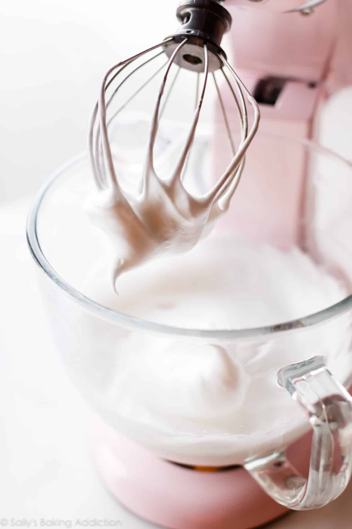 Whipped egg whites in a glass stand mixer bowl