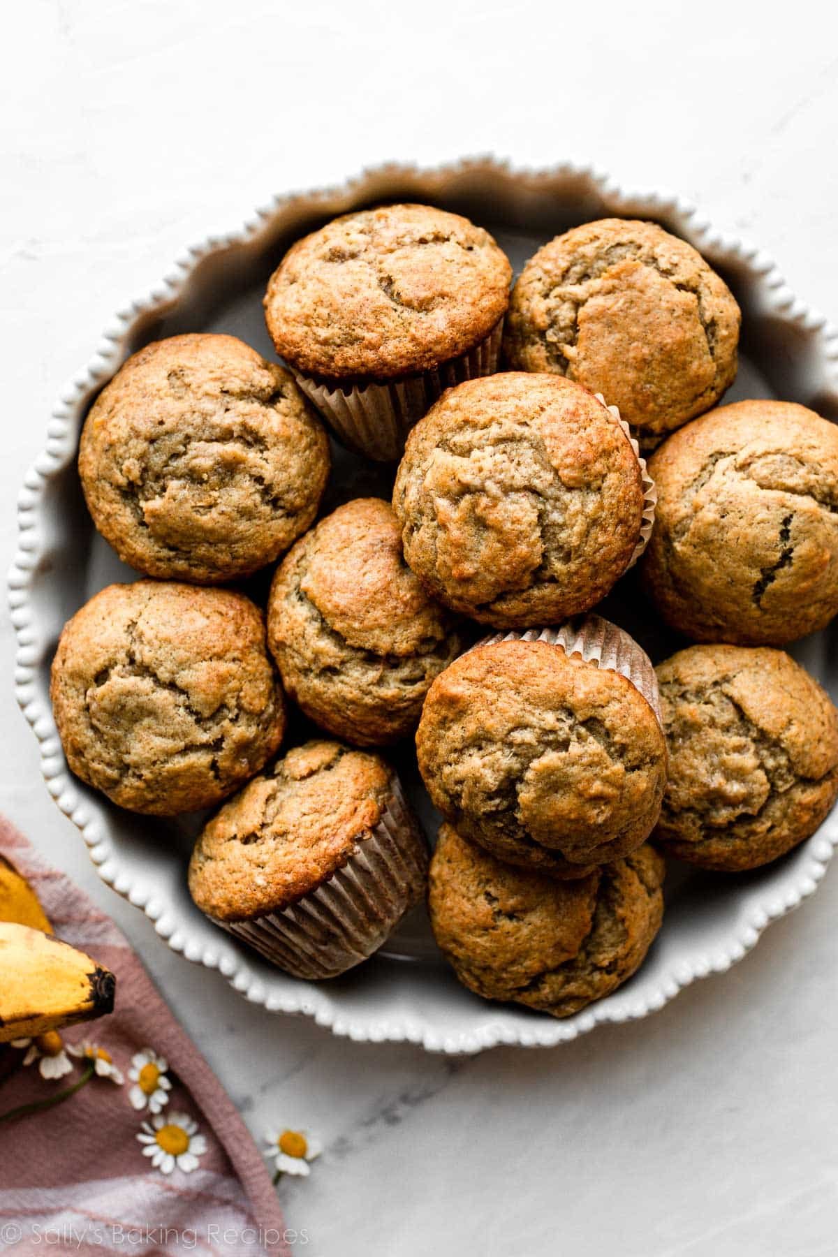 banana muffins piled together in white baking dish.