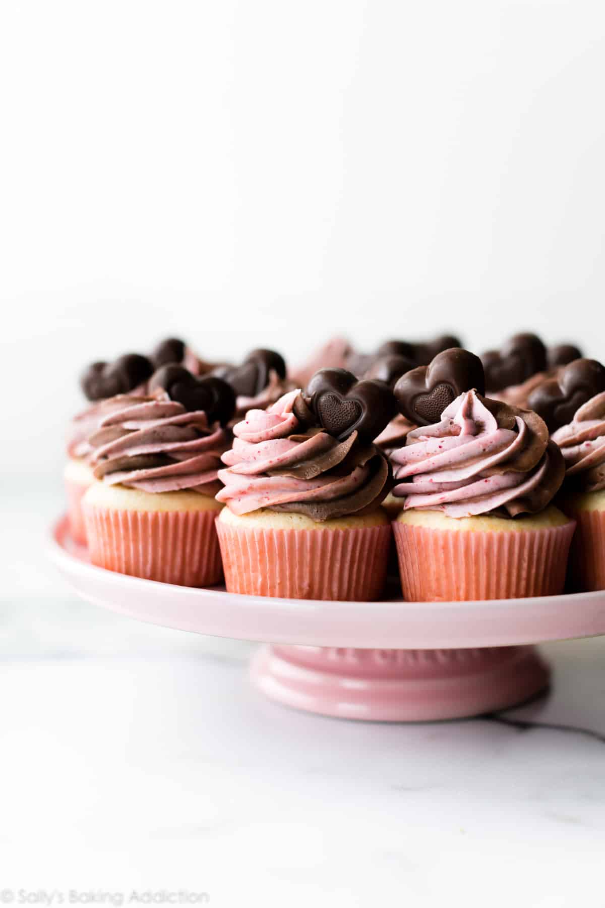 Strawberry Nutella frosted cupcakes on a pink cake stand