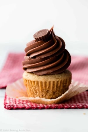 Peanut butter cupcake with swirl of chocolate peanut butter frosting and a peanut butter cup on top