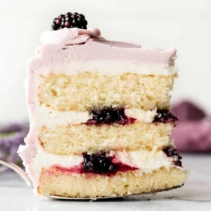 Slice of lavender butter cake with purple frosting and blackberry jam