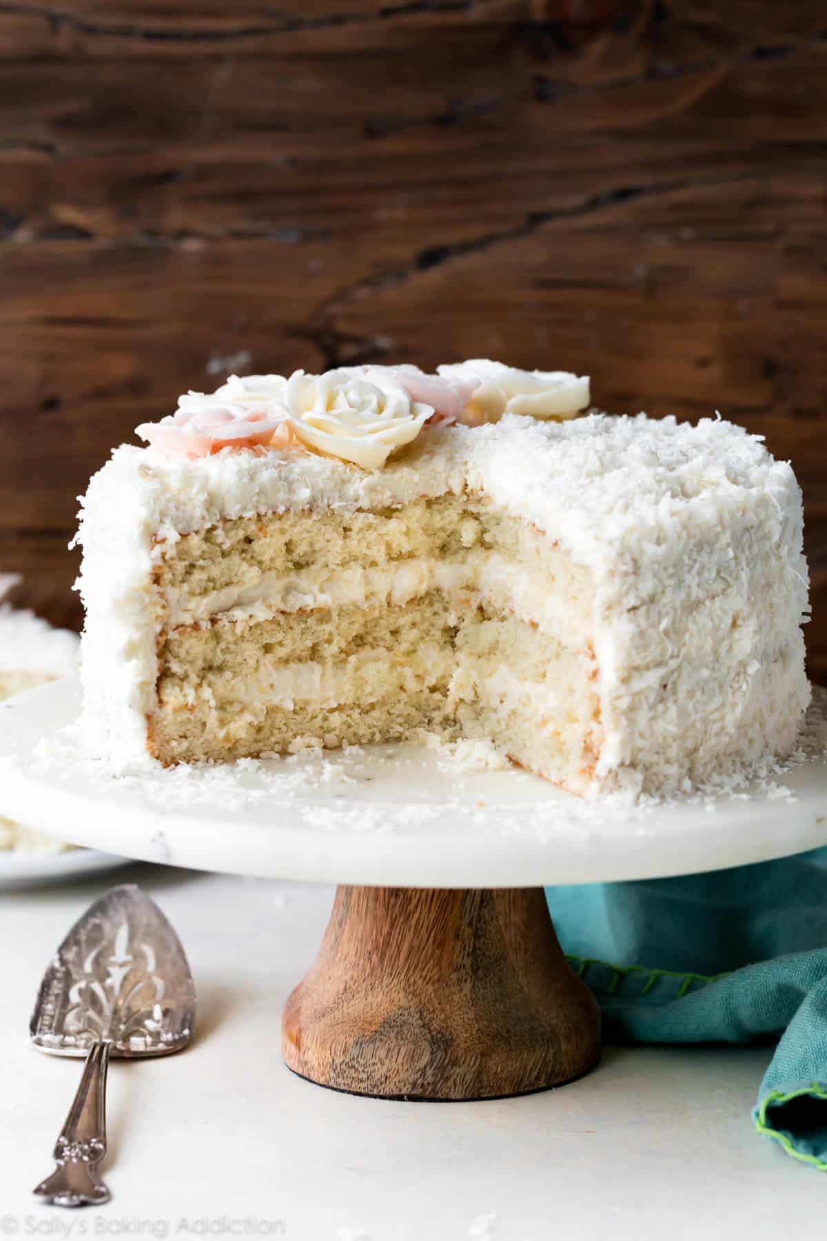 Coconut layer cake on wood and marble cake stand
