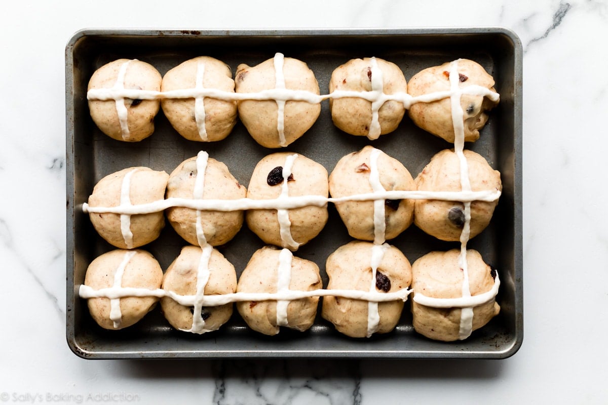 Unbaked hot cross buns in baking pan