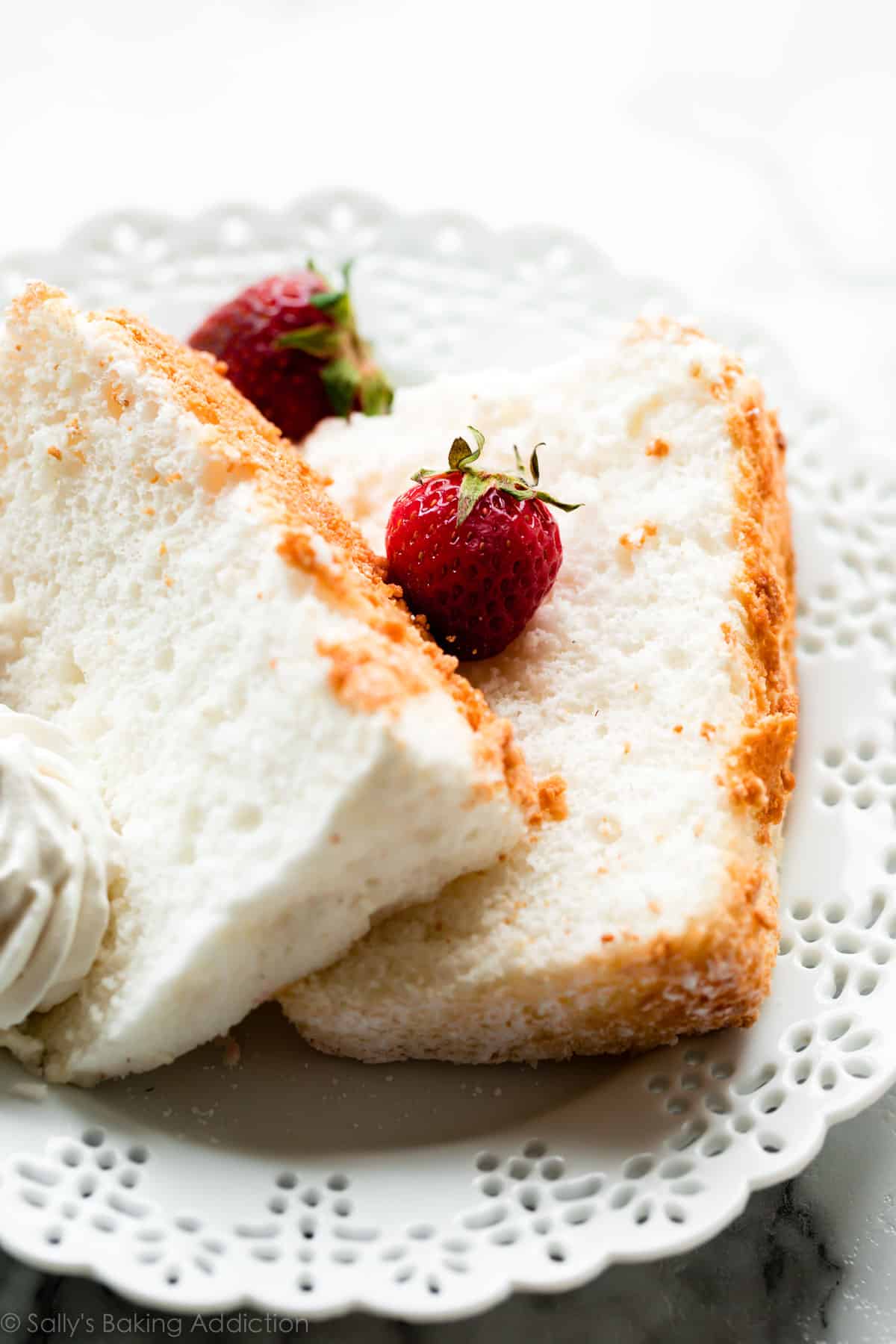 Angel food cake slices with strawberries on white plate