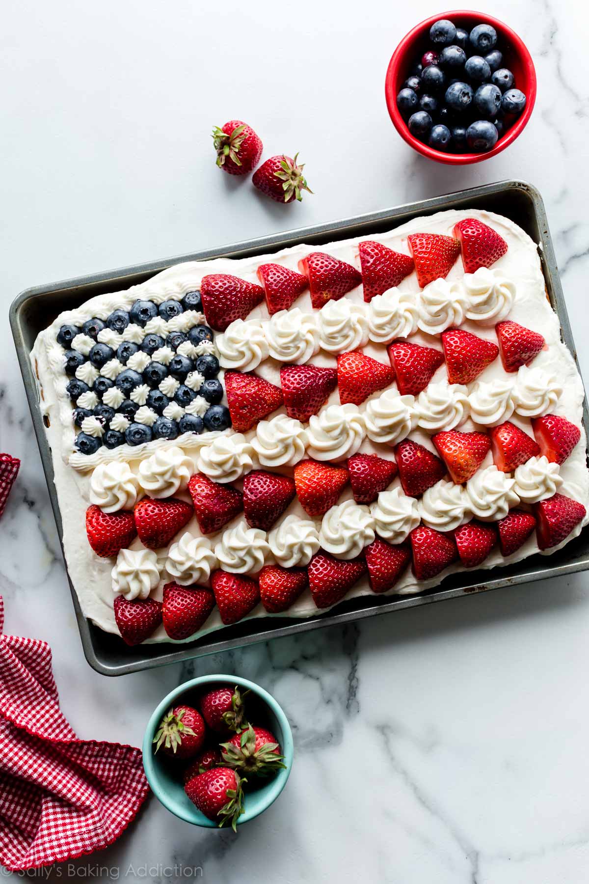 vanilla sheet cake decorated like an American flag with berries and frosting