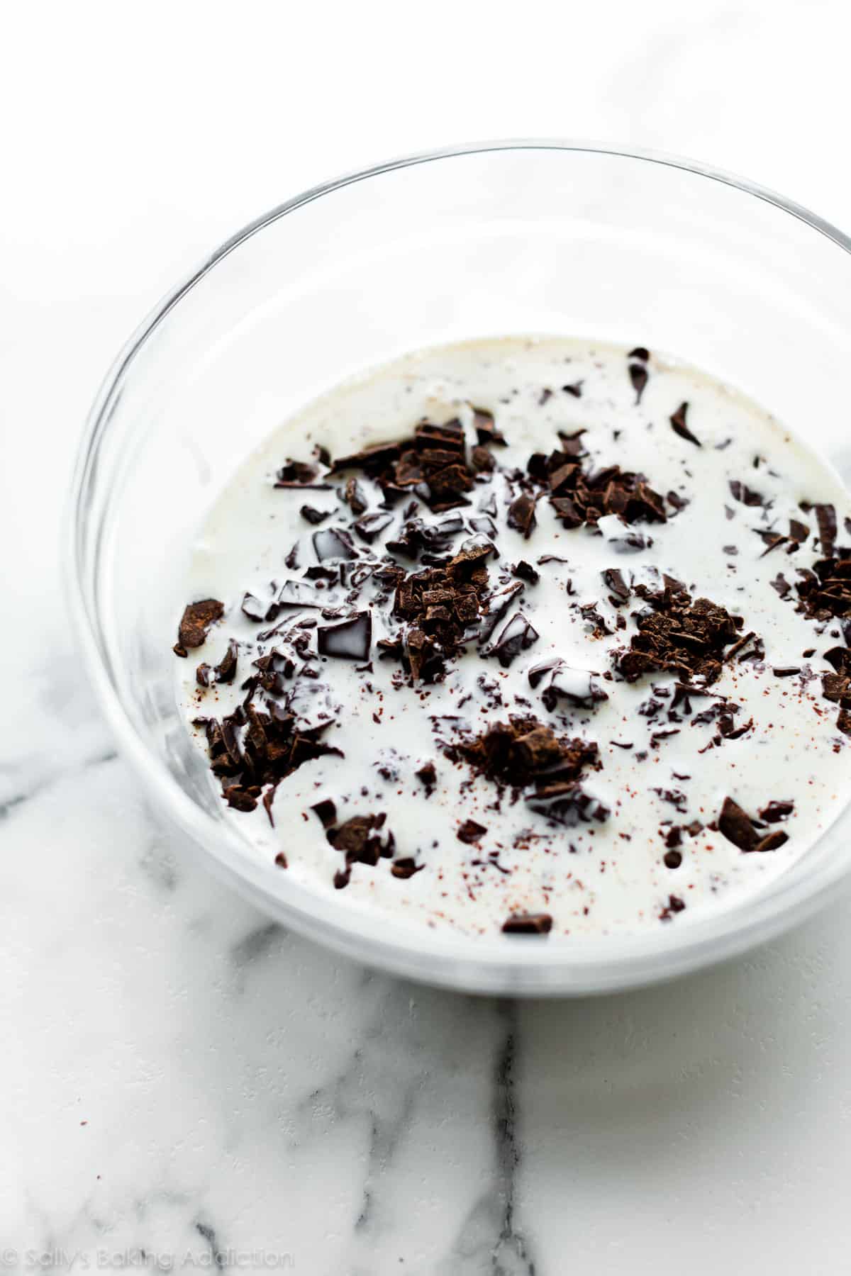 warm cream and chopped chocolate in a glass bowl