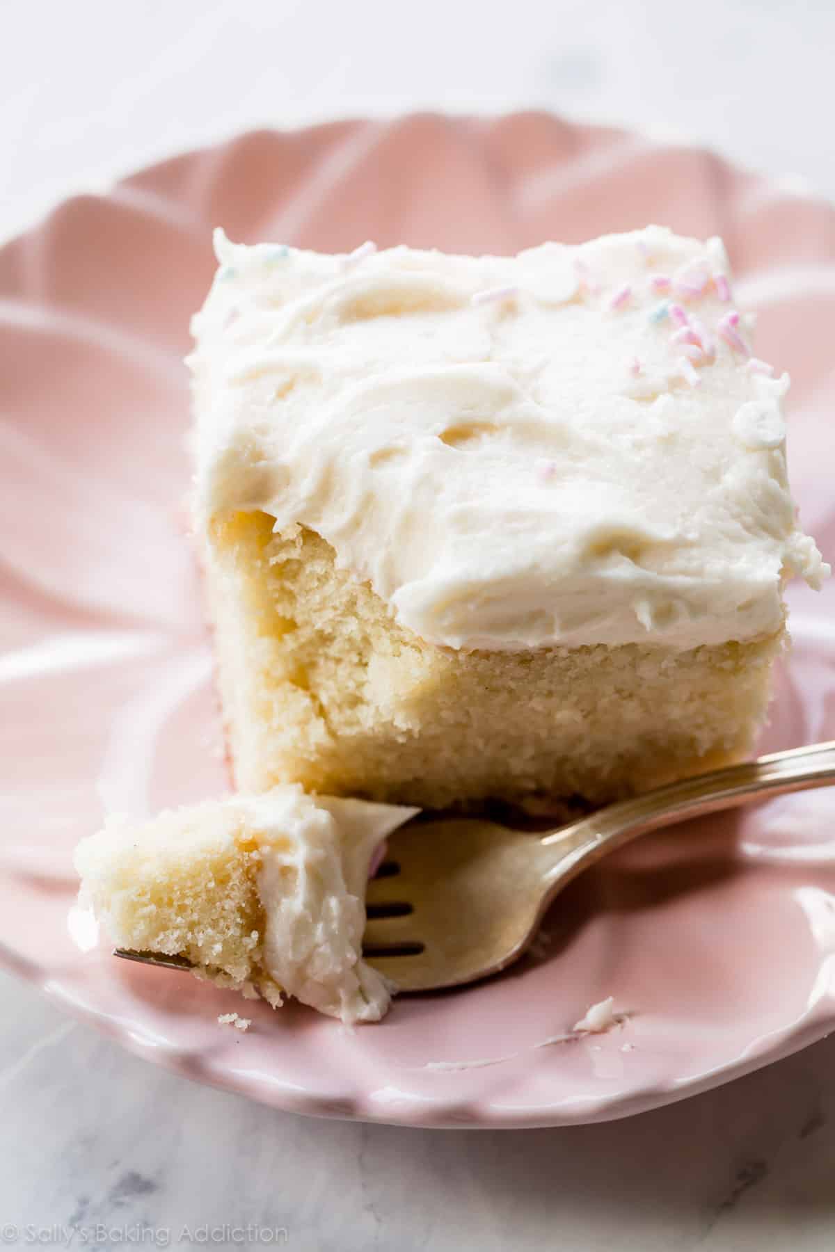 slice of vanilla sheet cake on a pink plate